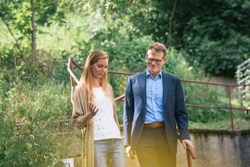 Patientin und Arzt spazieren drau&szlig;en