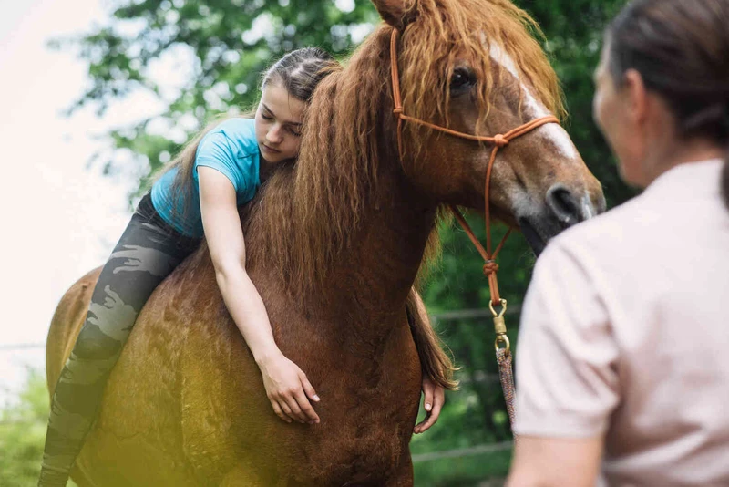m&auml;dchen sitzt auf einem pferd